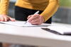 a woman in a yellow top writing on a page